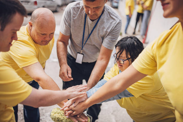 istock Group of volunteers holding hands 1887673262