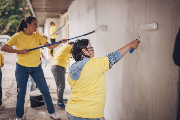 istock Volunteers painting wall together 1887675324