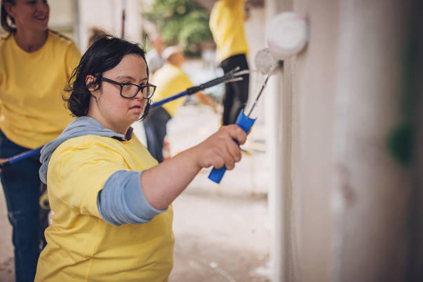 istock Volunteers painting wall together 1887678859