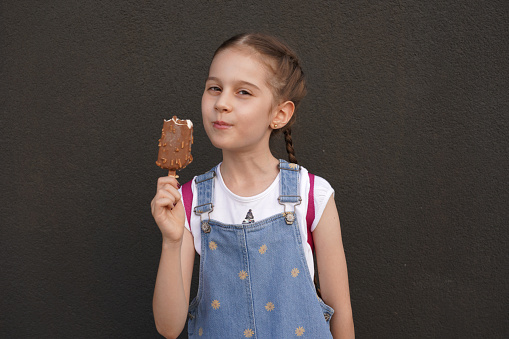Little girl with blonde hair eats ice cream