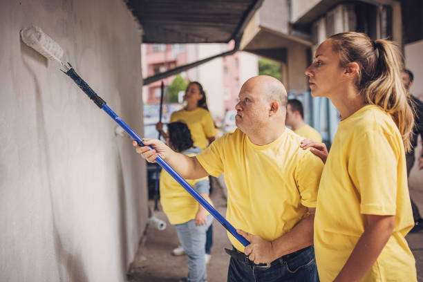 istock Volunteers painting wall together 1887681410
