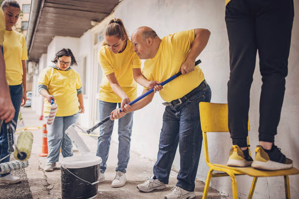 istock Volunteers painting wall together 1887682437