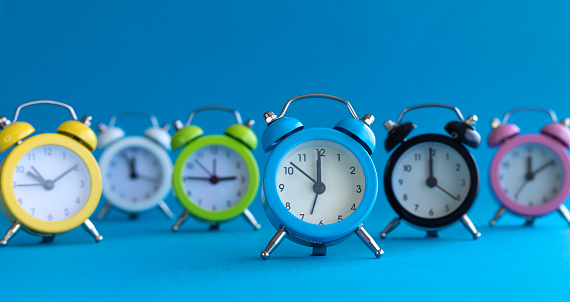 Alarm clocks in different colors, blue background.