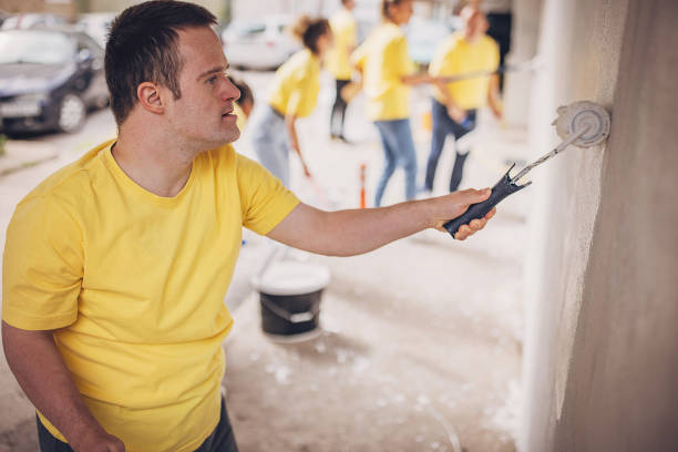 istock Volunteers painting wall together 1887693327