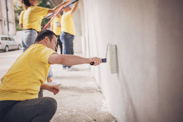 istock Volunteers painting wall together 1887694346