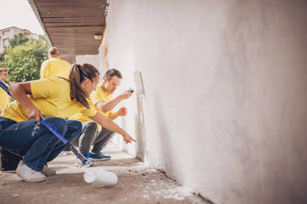 istock Volunteers painting wall together 1887695359