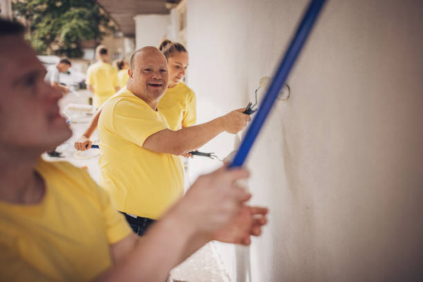 istock Volunteers renovating wall together 1887697421