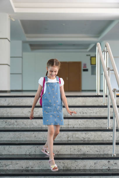 istock Little girl with a backpack comes down the stairs 1887762505
