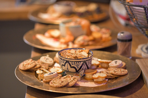 Plates of hors d'oeuvre lined up on a wooden kitchen surface