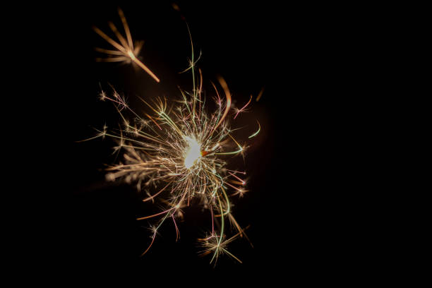 istock A perfectly formed sparkler resembling a delicate dandelion flower seeded head, exploding sparkler with delicate strands of warm light with hints of gold, red and green with the background of a dark nights sky 1887775706