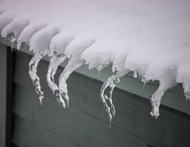 istock Close up of ice hanging from roof 1887783096
