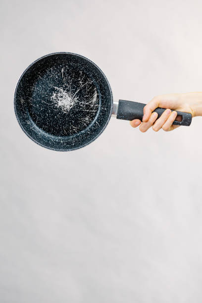 istock Hand holding scratched frying pan 1887789992