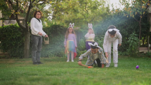 Group of children playing egg and spoon race outdoors
