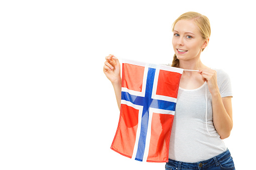 Blonde teenage girl holding flag of Norway. Education. Norwegian language school. Visit Norway concept.