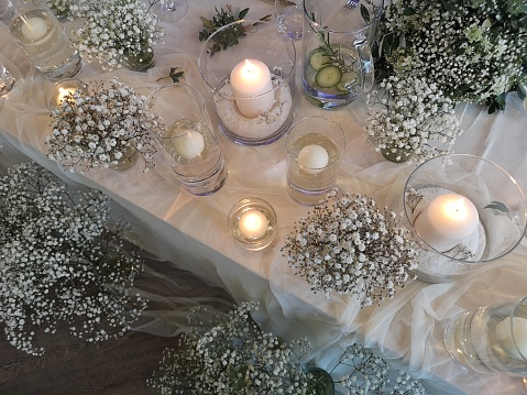 An elegantly adorned table for a special occasion, featuring lit candles, fresh flowers, and other decorative elements