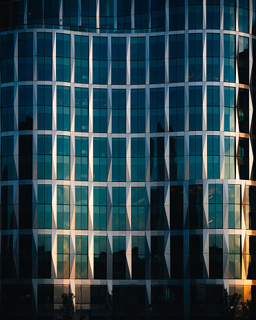 The sunrise reflecting off of a curved glass building in Boston’s seaport district.