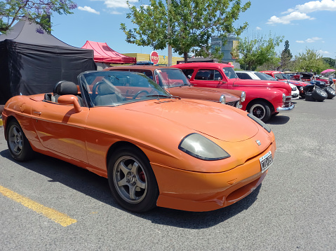 Buenos Aires, Argentina - Dec 10, 2023: Old orange Fiat Barchetta circa 1998 sporty stylish Italian roadster convertible at a classic car show in a parking lot. Sunny day