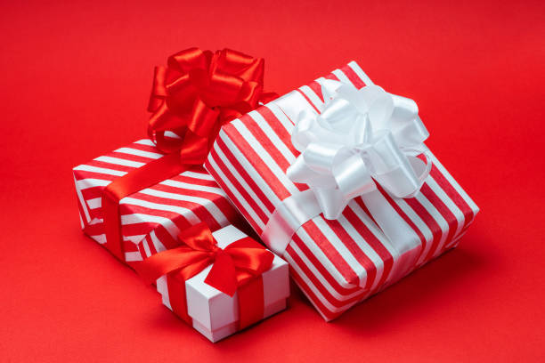 istock Close up set of decorated present boxes isolated over bright colored red paper background 1887877655