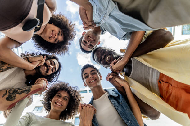 istock Portrait of a young friends looking down outdoors - low angle view 1887899406
