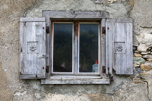 Wall and green window of traditional wooden american wooden cabin viewed from the outside