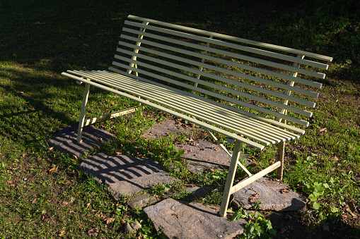 concrete bench for rest in a green park with trees