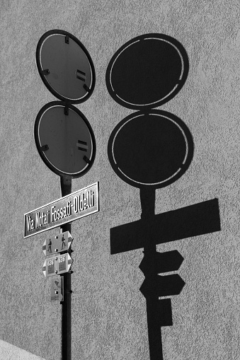 Street signpost with shadow on a wall in the village of Meride, Ticino, Switzerland