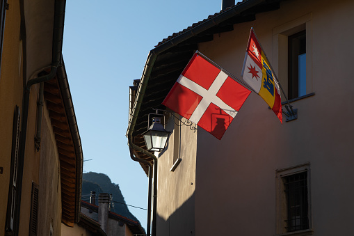Swiss flag on a house facade in a village, Meride, Ticino, Switzerland