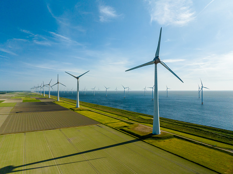 Aerial View of Wind Turbines and Agriculture Field  in the Early Morning at Sunrise.