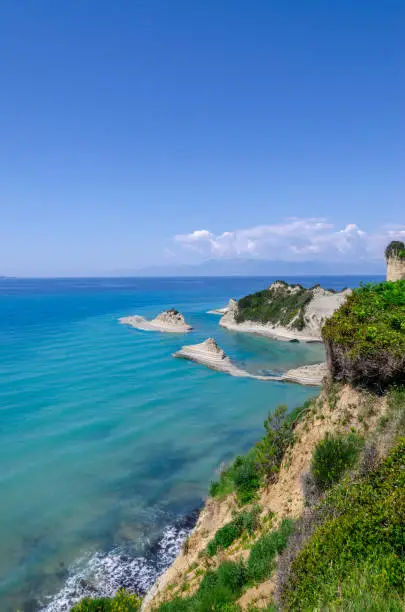 Photo of Cape Drastis cliffs near Sidari and Peroulades on Corfu island in Greece. Famous rock formations with small beach and rugged coastline. Popular Greek destination for summer vacation