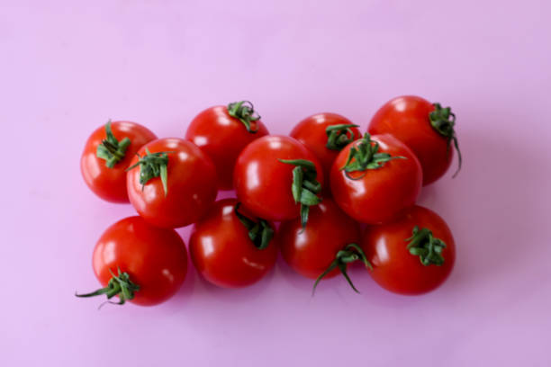 istock Cherry tomatoes isolated on a pink background. 1887998890
