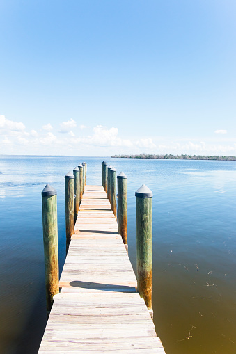 Long empty jetty in front of an island at the Caloosahatchee River near Sanibel Island, the Caloosahatchee river flows into the Gulf of Mexico, Florida, USA.