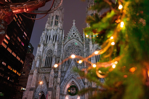 St. Patrick's Cathedral pokes out from behind some Christmas lights on a tree