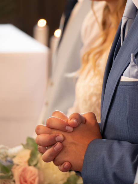 istock CLOSE UP, DOF: Clasped groom's hands praying during a wedding ceremony in church 1888064582