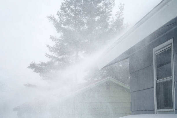 istock strong wind blowing snow off the roof in blizzard 1888073350