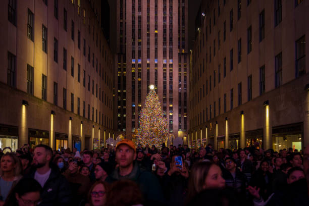 Rockefeller Center Christmas Crowd Rockefeller Center crowd awaits the Saks/Christian Dior holiday light show. December 2023. New York City, NY. USA rockefeller ice rink stock pictures, royalty-free photos & images