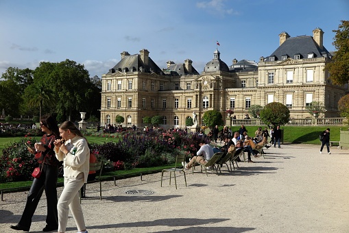 Paris, France - Oct. 4, 2023:  People enjoy a sunny afternoon in the Jardin du Luxembourg, in front of the Palais du Luxembourg, on the Left Bank of the Seine River.