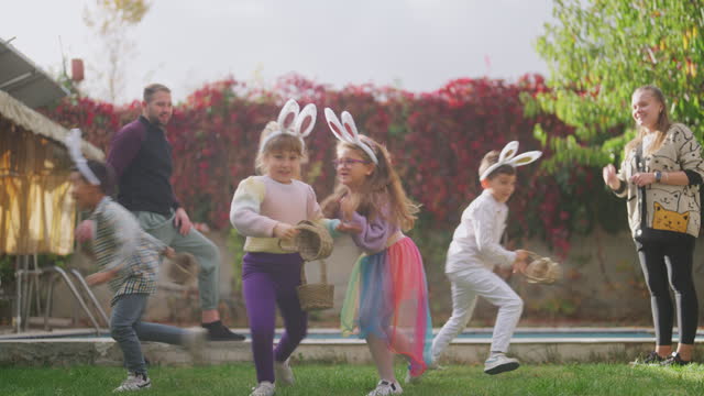 Group of excited children running around in garden on Easter egg hunt game