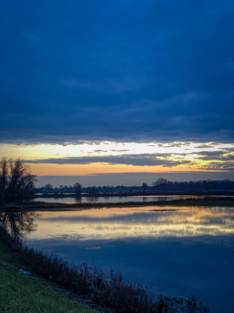 istock Sunset over a river in the countryside in the Netherlands with dramatic clouds. 1888190414