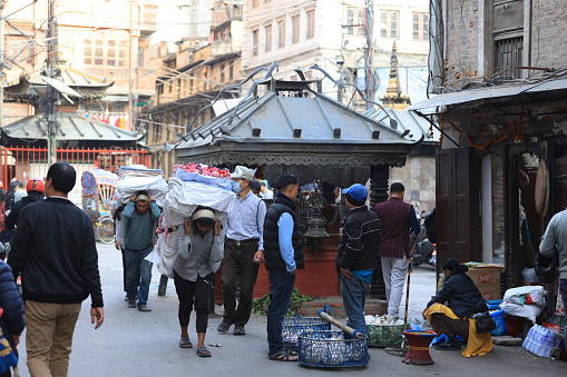 Kathmandu, Nepal - November 24 2023:an unidentified coolie walk with his huge bag. unemployment rate increase in 2024