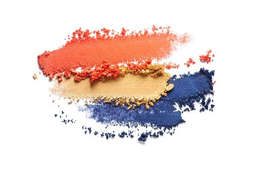Cosmetic ultramarine navy blue camel yellow beige orange palette smeared eye shadow swatch isolated on white background