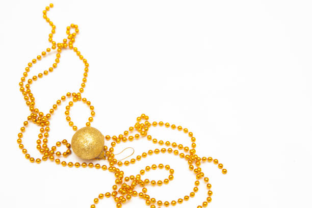 Copy space for Christmas with cookie baking dish (red star and green Christmas tree), gold beads and cinnamon sticks on a white background. Christmas and New Year's mood.