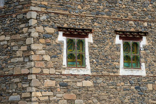 The window of a stable near an old mill. It has an arch and glass panels. The iron frame is a bit rusted. Location:  Neuharlingersiel, East Friesland, Germany