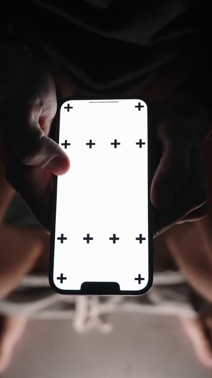 Vertical video. A Man at Night on the Toilet Scrolls Through Photos and Likes Them. Concept of Social Media Browsing in the Bathroom. Chroma Key Layout on the Smartphone in Hand.