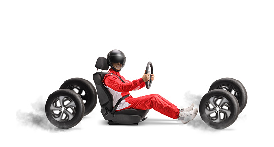 Car racer with a helmet in a car seat on four wheels isolated on white background