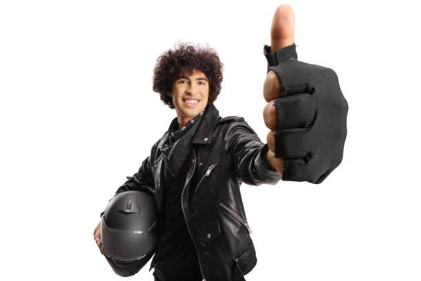 istock Handsome guy in a black leather jacket holding a helmet and gesturing thumbs up 1888448484