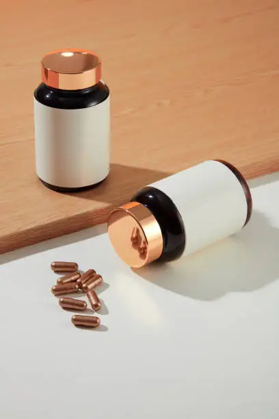 Two white-label medicine bottles are placed on the table with hard capsules. Using functional foods helps provide adequate nutrients similar to those provided by fruits, vegetables, nuts and grains.