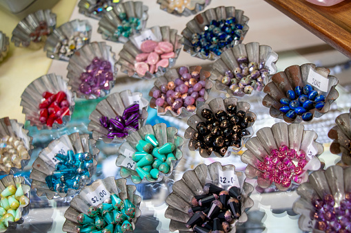 Close-up photo of small multi-colored beads in metal trays.