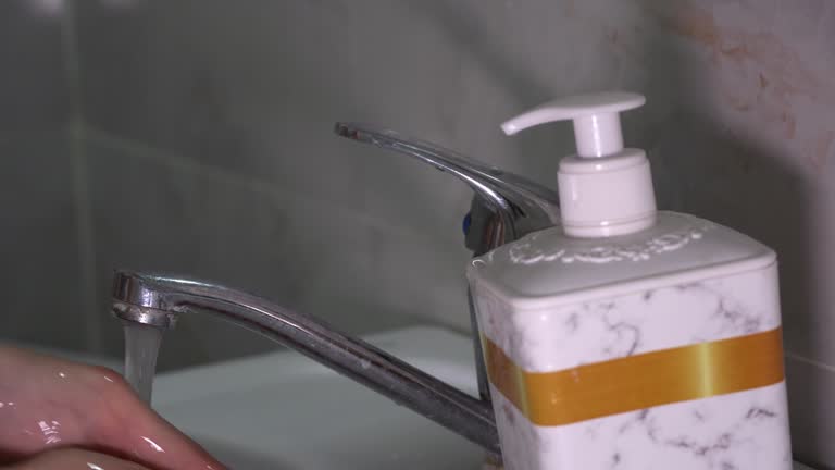 A man washes his hands in a washbasin using liquid soap. Homemade routine, personal hygiene, home procedures, cleaning