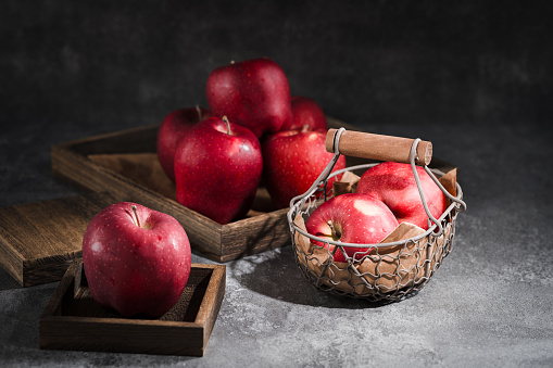 red apples in a wicker basket on dark background