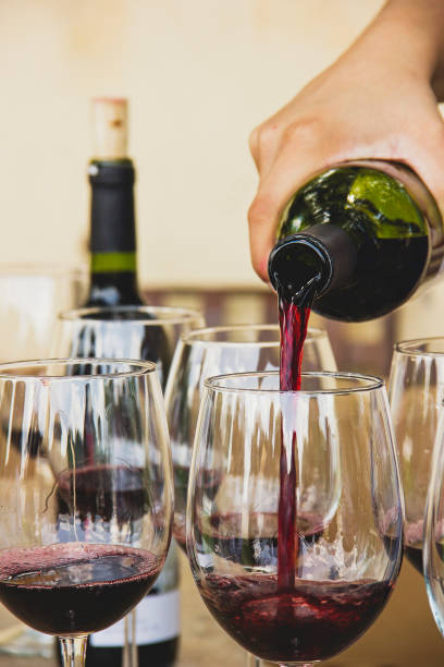 istock Hand filling red wine glasses 1888752247
